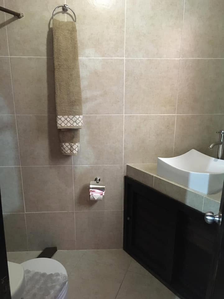 Baño privado con lavabo de mesa y toallas colgadas