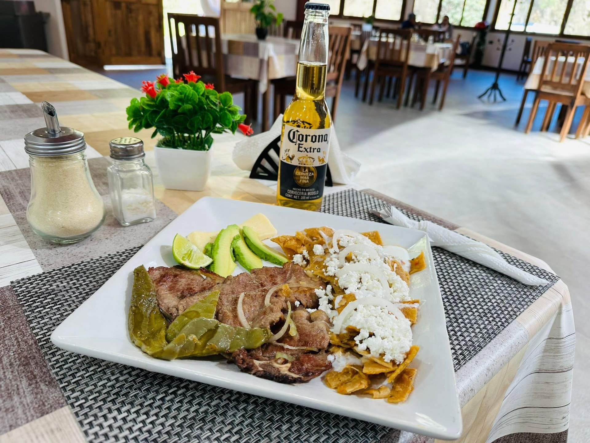 Plato fuerte con carne asada, chilaquiles, aguacate y limón