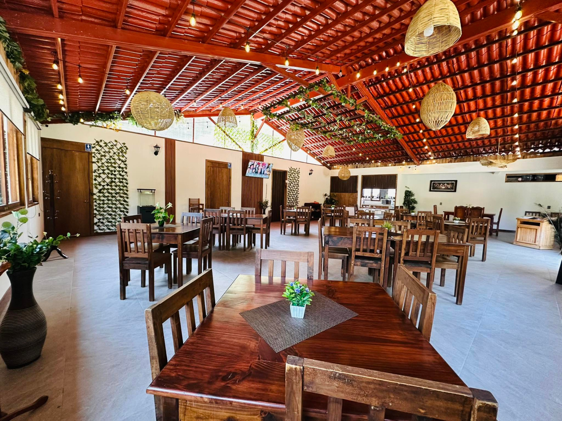Comedor del restaurante Rincón Minero, con mesas de madera, techo de teja y luz cálida